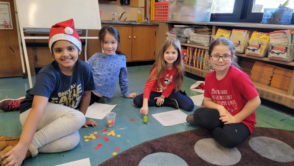 Four students playing dreidel game