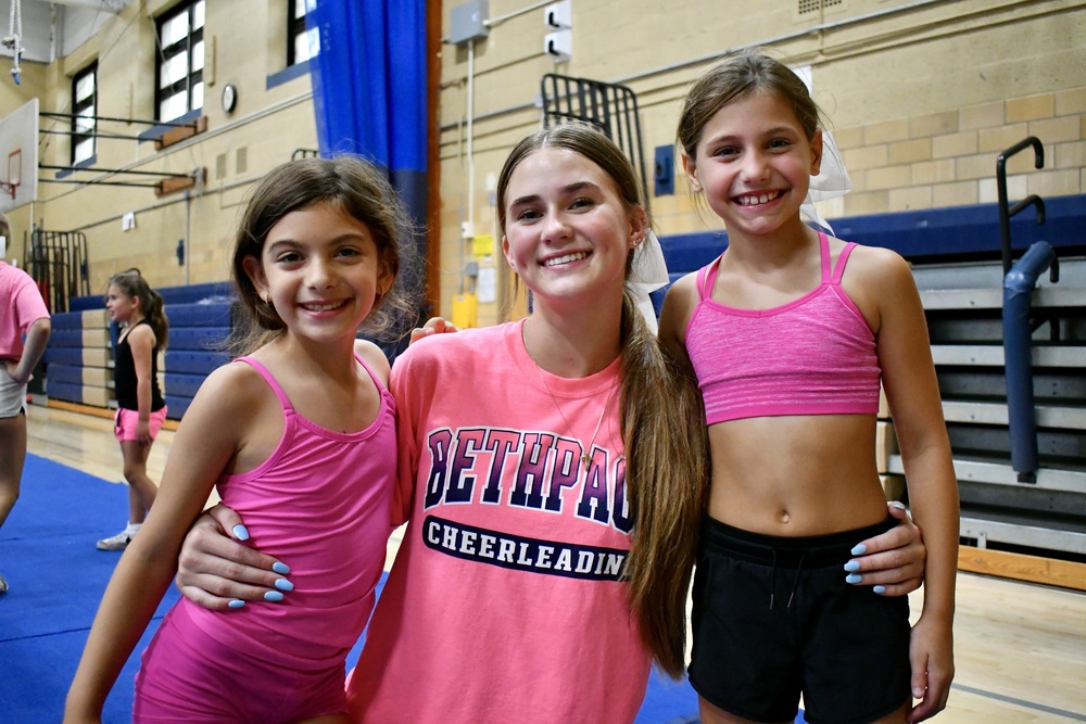 Two elementary students smiling with varsity cheerleader