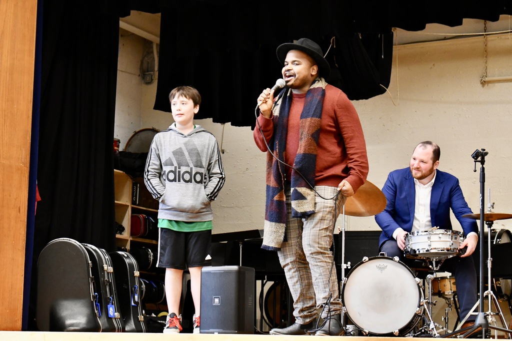 Student standing with singer on stage