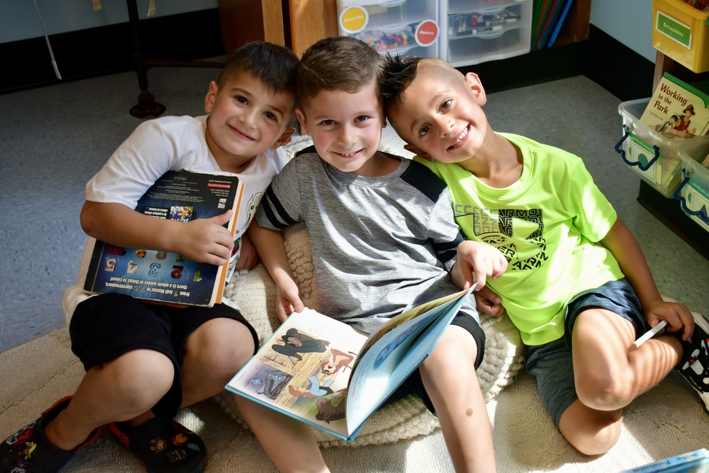 Three boys reading together